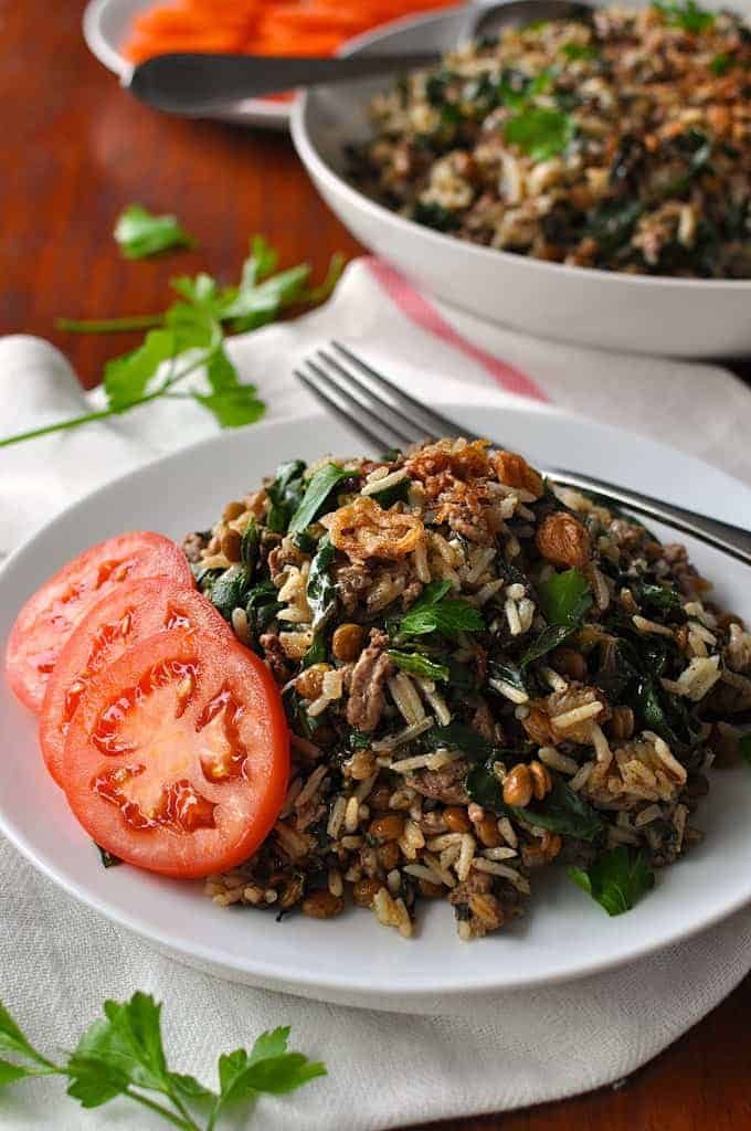 Middle Eastern Lamb and Lentil Rice Pilaf on a white plate with tomatoes