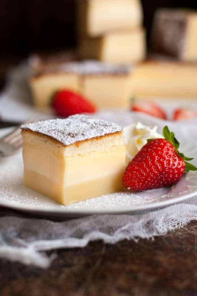 Magic Three Layer Custard Cake with strawberry on a white plate