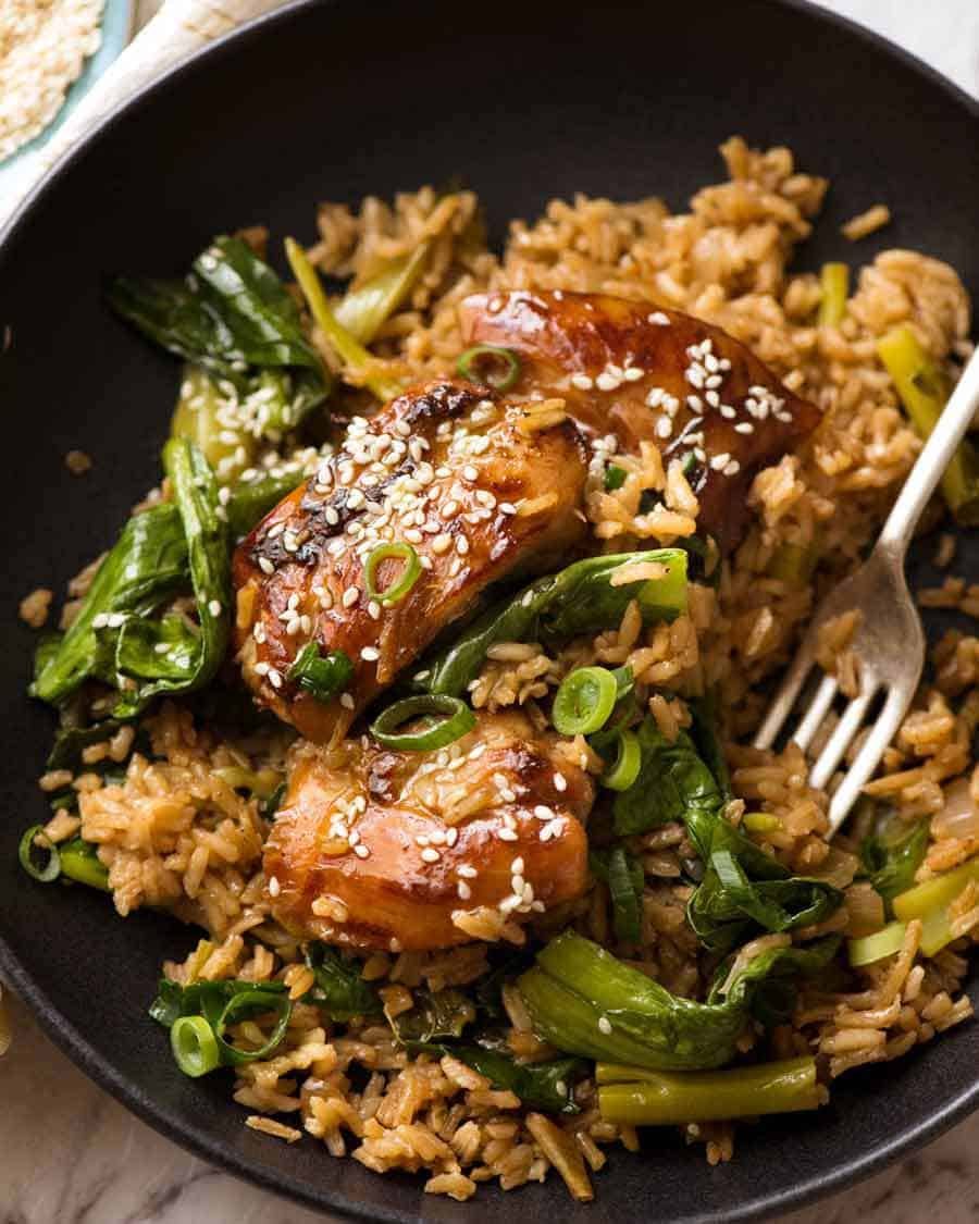 One Pot Chinese Chicken and Rice in a black bowl garnished with sesame seeds, ready to be eaten