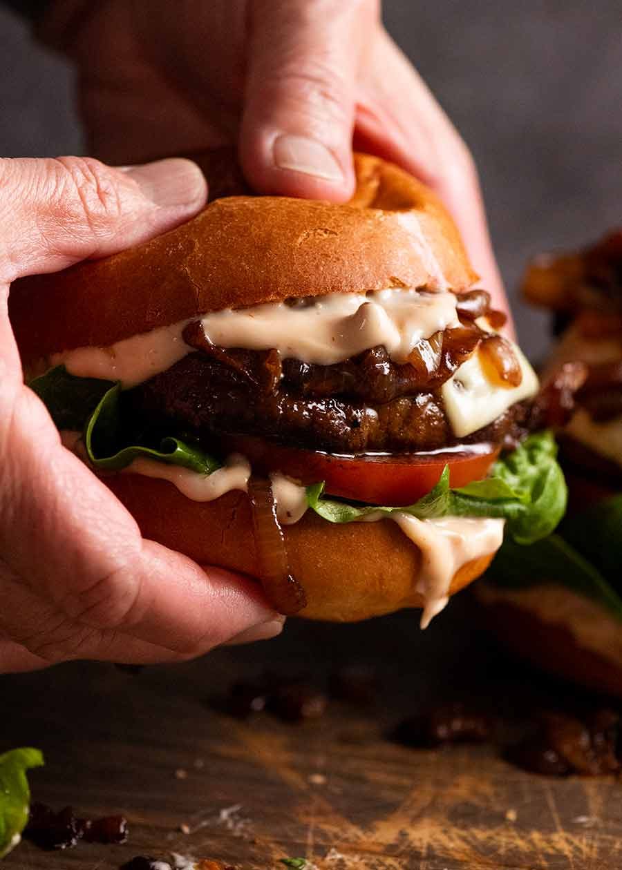 Hand holding juicy Swiss Mushroom Burgers
