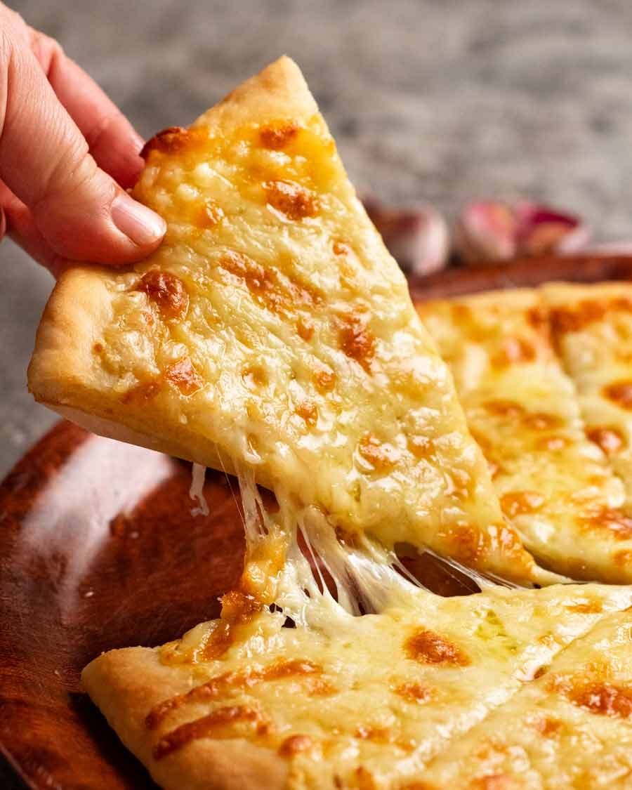 Picking up a slice of Garlic cheese pizza